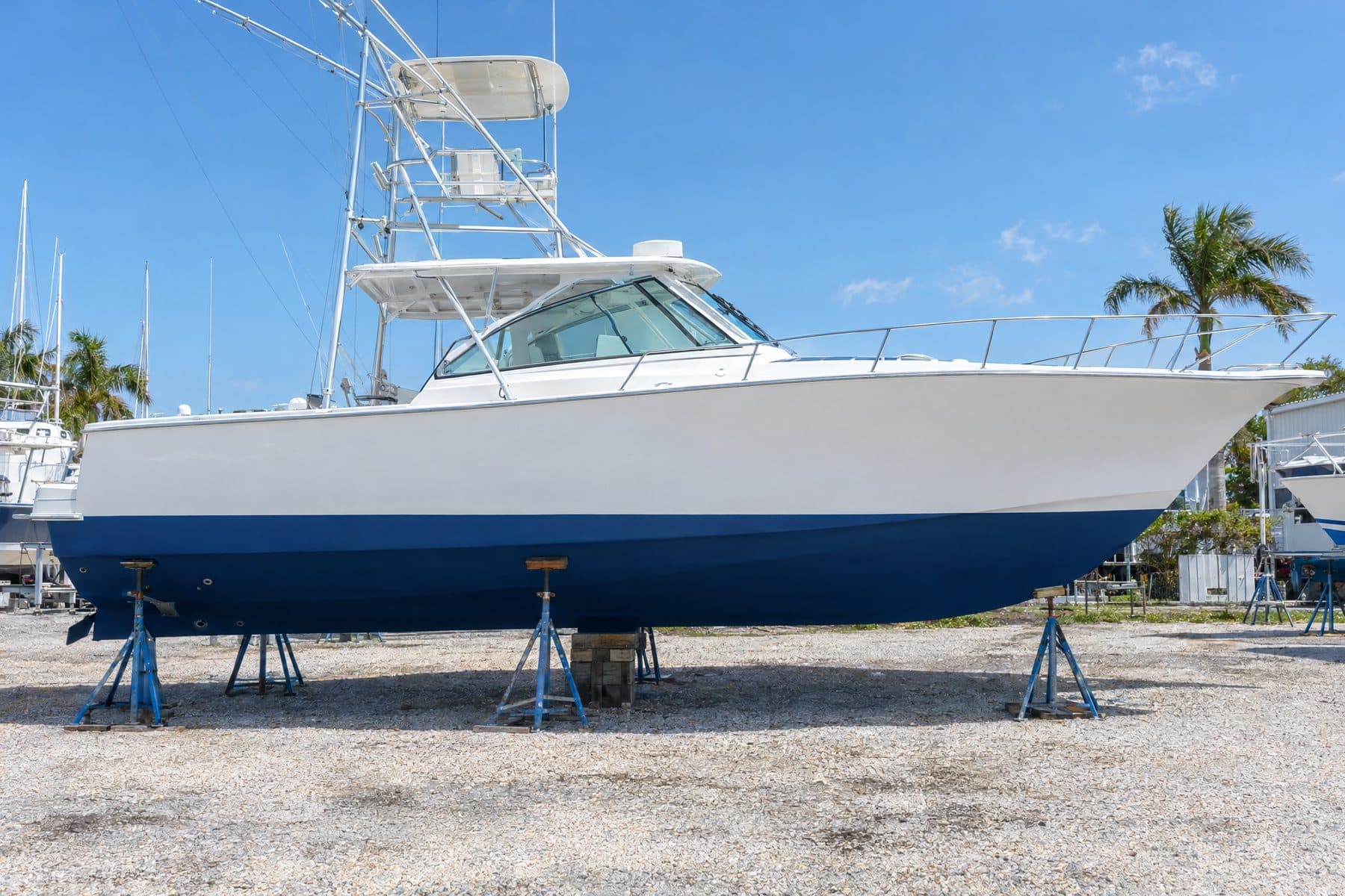 Illustration: the same hull after a bottom job, smooth fresh dark blue antifouling paint below a clean waterline